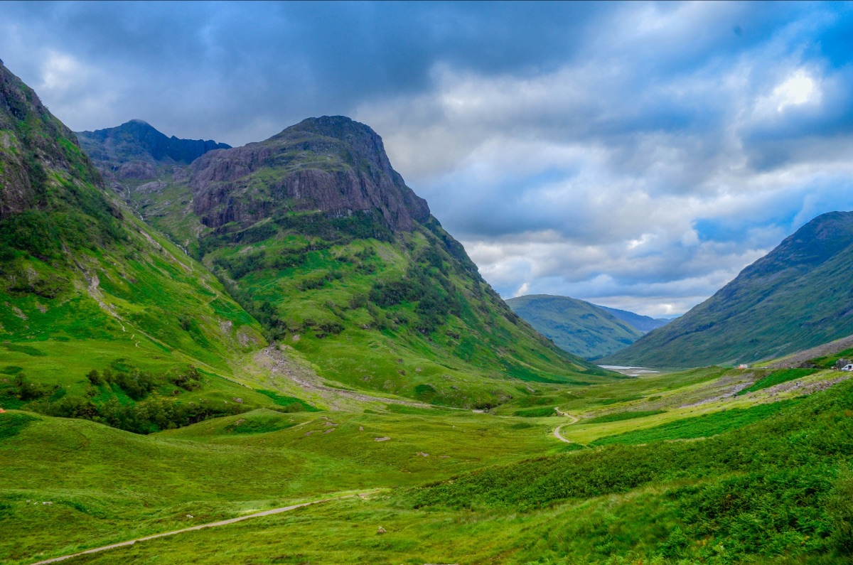 Green mountain vista with blue cloud sky